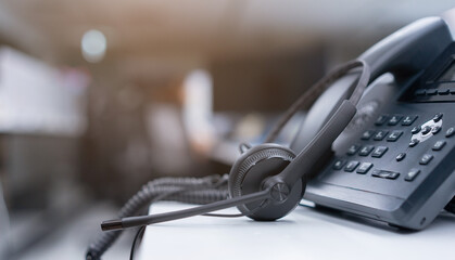 close up black headset with telephone in operation room to communicate with vendor or client for call center and hotline service concept - obrazy, fototapety, plakaty