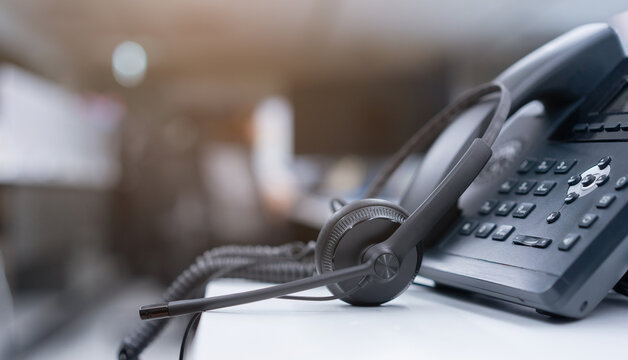 close up black headset with telephone in operation room to communicate with vendor or client for call center and hotline service concept