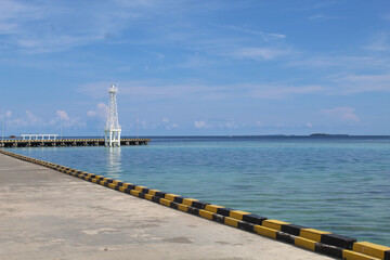 Karimun Jawa Port or Harbor, the empty dock or the paved road, with clear blue sea water and blue...