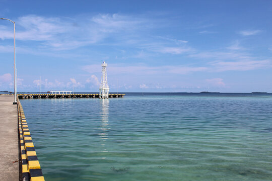 Karimun Jawa Port or Harbor, the empty dock or the paved road, with clear blue sea water and blue sky