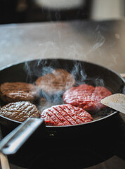 Frying pan with burgers / hamburger patties on high heat, home cooking cheeseburgers