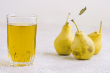 Juice of pears  in a glass on a white wooden background