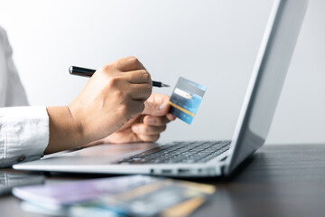 Fototapeta na wymiar Focused businesswoman utilizing a credit card to manage transactions efficiently at a contemporary desk. Professional working highlighting modern finance, online shopping, digital technology.