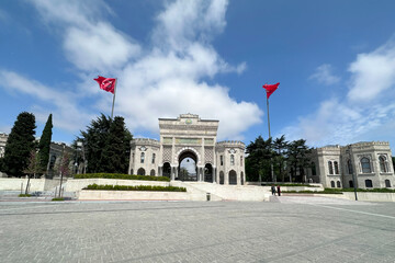 Main entrance gate of Istanbul University on Beyazit Square with Turkish flags. Istanbul University Gate panoramic landscape view. Ancient ottoman arc