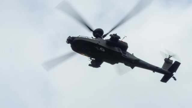 close-up of British army Boeing Apache Attack helicopter gunship AH64E AH-64E flying low overhead, Wiltshire UK