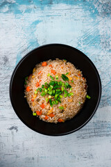 Rice with chicken, carrots, onions, soy sauce, sesame seeds and green onions.