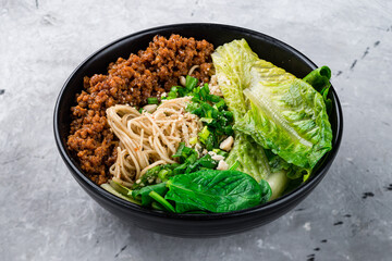 Dan Dan noodles with minced pork, oyster sauce, romaine lettuce, honey, pepper, spinach and garlic in a plate.