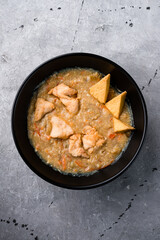 Braised chicken with tofu, carrots, onions and potatoes in a plate.