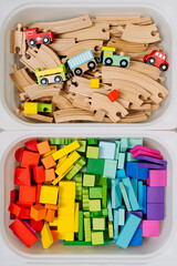 Plastic containers with colorful toy blocks, toy train and wooden railway. Toy Storage boxes in the children's room. Organizing and Storage Ideas in nursery.  Top view