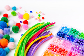 Set for children's crafts. Pipe Cleaners, beads and colorful pom-poms. Different multi-colored supplies and materials for DIY art activity for kids. Motor skills, creativity and  hobby.