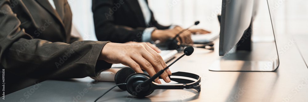 Aufkleber panorama focus hand holding headset on call center workspace desk with blur background of operator t