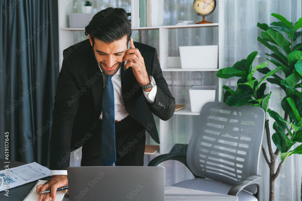 Poster diligent businessman busy talking on the phone call with clients while working with laptop in his of