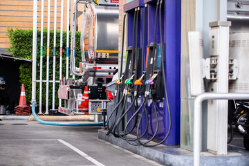Selective focus to fuel tanker truck with blurry fuel dispenser is transferring fuel to storage...