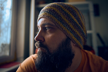 A man with a beard wearing a striped hat and t-shirt