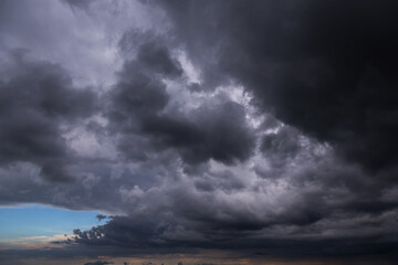 Epic Dramatic storm dark grey cumulus rain clouds against blue sky background texture, thunderstorm