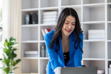 Young beautiful asian woman working in corporate office, businesswoman working in office attentively to grow and modernize start-up business, she is analyzing company's market and financial data.