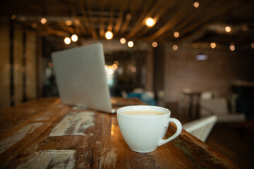 workspace with modern laptop and cup of coffee, close-up