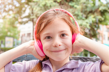 Cute child girl with headphones  outdoor