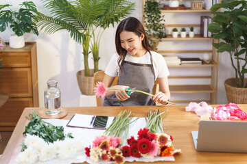 Flower shop concept, Female florist cutting gerbera with scissor to prepare for making flower vase