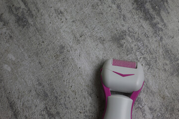 Electric callus remover. Sanding roller for removing rough skin from the feet. Pink grinding head...