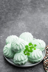 Mint marshmallows on ceramic plate on gray background
