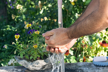 Fototapeta premium Washing hands. Man washing his hands in the garden. Hygiene and Cleaning Hands. 