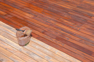 Wood deck refreshing, paint brush on the bucket with oil