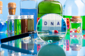 DNA pill on the background of a laboratory table with medicines and preparations. View through a...