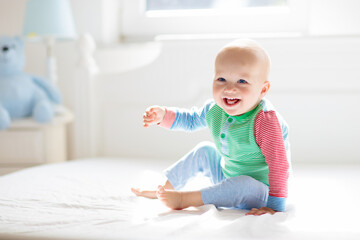 Baby boy crawling on bed