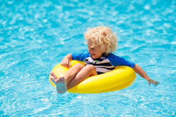 Fototapeta na wymiar Child in swimming pool. Kids swim. Water play.