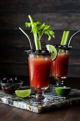 Refreshing Caesar cocktails, ready for drinking, against a dark background.