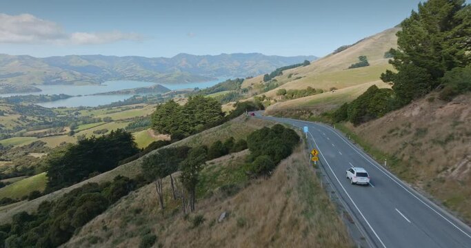 Aerial: Country road, cars and farmland. Bank Peninsula, New Zealand