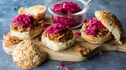 Toasted pulled pork buns topped with pickled beet and cabbage sauerkraut.