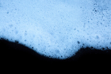 L'écume d'une vague sur un plage de sable volcanique. 
