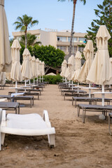 Beach in Antalya, Turkiye. Umbrellas and sun loungers in the assembled state on the beach.
