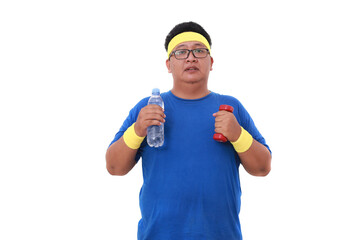 Asian overweight man in sportswear standing while holding a bottle of drink and dumbbell. Isolated - obrazy, fototapety, plakaty