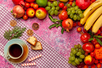 Fototapeta na wymiar top view fresh fruit composition colorful fruits with cup of tea and cakes on pink background fruit fresh mellow color ripe