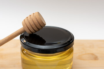 A jar of natural honey and a special wooden spoon