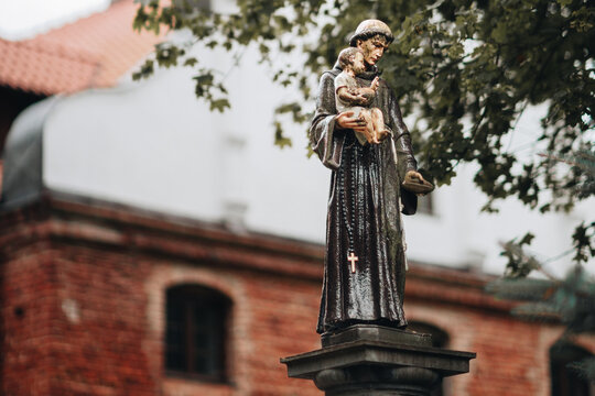 An old, dilapidated statue of St Anthony of Padua with Jesus in his arms.