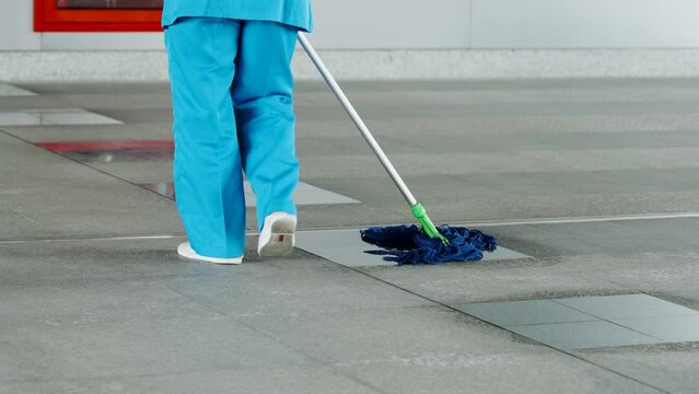 Close-up long-handled mop, which is abusing cleaning staff use mop dirty floor because it is public area where there are many people walking through all day, make place look clean all time.