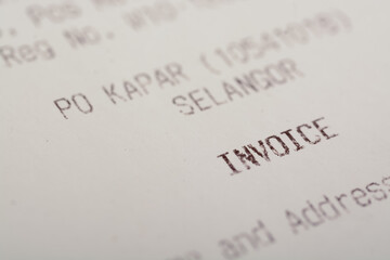 A close-up view of the word "INVOICE" on a sales receipt.