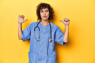 Curly-haired Caucasian woman nurse on yellow studio feels proud and self confident, example to...