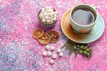 half-top view cup of tea with white sweet confitures on the pink background candy sugar sweet tea color