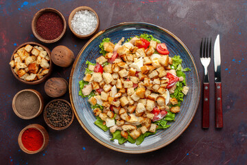 top view caesar salad with sliced vegetables and rusks inside plate on dark background vegetables...