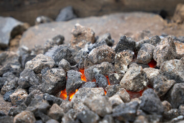 A fire burning under coals in a forge