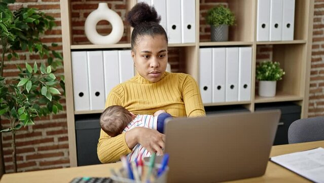 Mother and son business worker working while breastfeeding baby at home