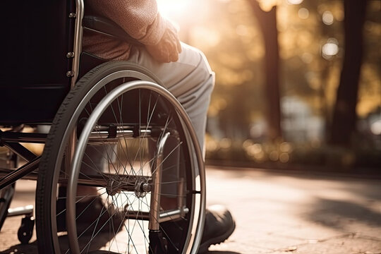 Hand of a lonely elderly man in a wheelchair in the park, created with Generative AI