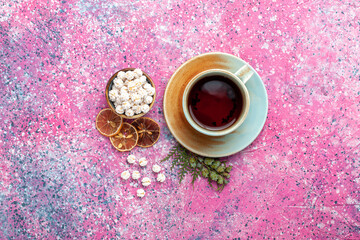 top view cup of tea with white sweet confitures on the pink background candy sugar sweet tea color