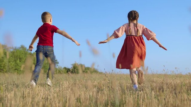 Kids running, sky. Happy family. Children boy, girl play in park, Friends run together raising their hands, dream is to fly to travel.Creative imagination of children, concept of active play in nature