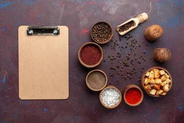 Fototapeta na wymiar top view different seasonings with dried rusks and notepad on the dark desk pepper ingredient product bread photo